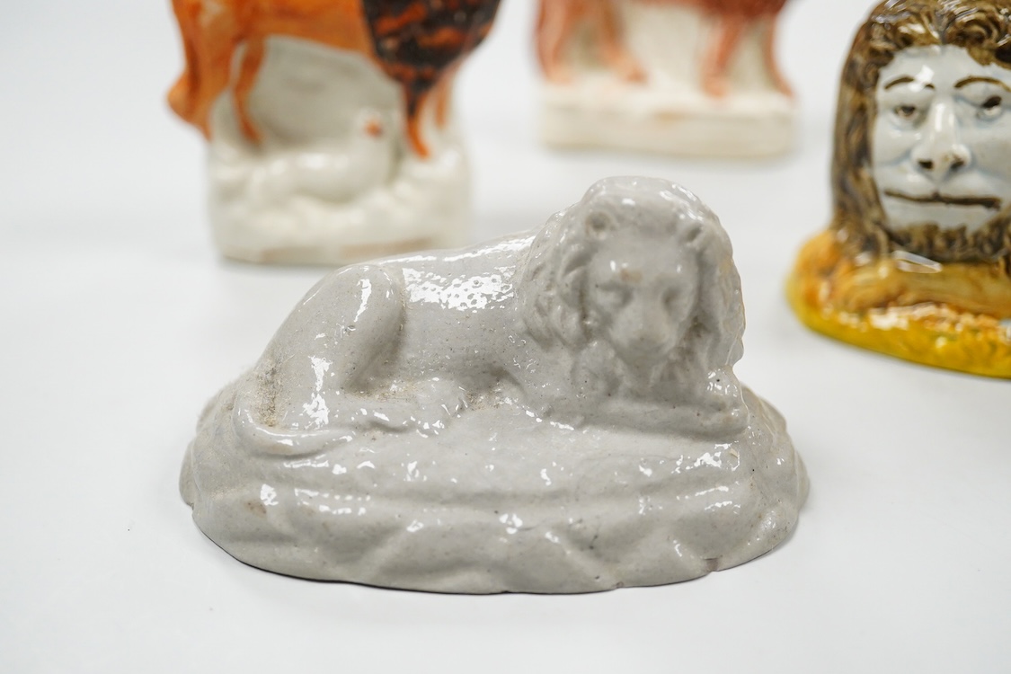 A rare Staffordshire Pearlware model of a recumbent lion, c.1810, and three Staffordshire pottery models of lions, mid 19th century, largest 11cm wide